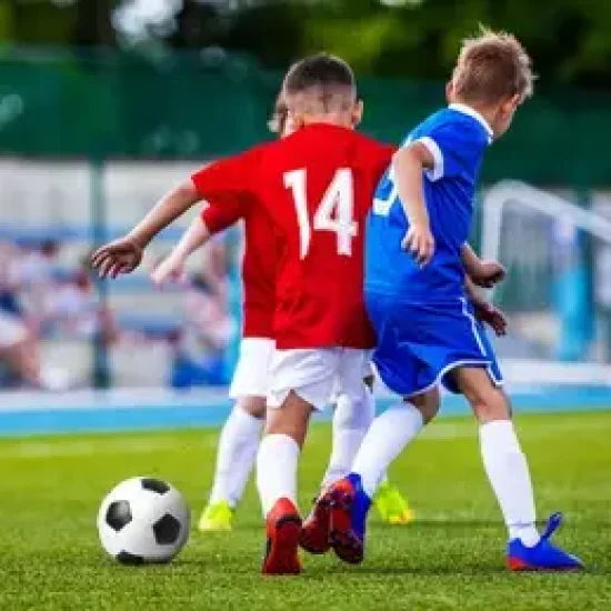 boys-kicking-soccer-ball-on-260nw-564086689